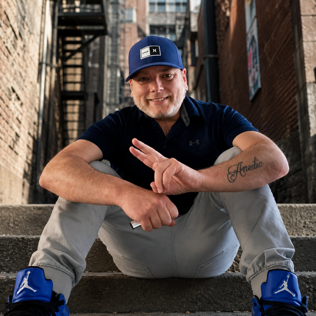 DJ Terry Bevvan in blue Jordans in an urban alley